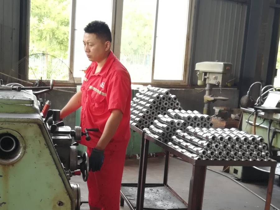Two workers are operating the sucker rod machine.