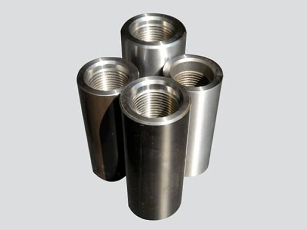 Four smooth surface sucker rod couplings on the gray background.