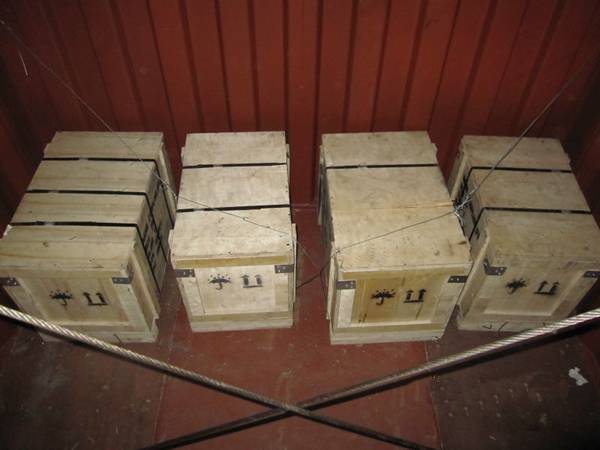 Four wooden boxes in the container and fastened by the steel wire rope. 